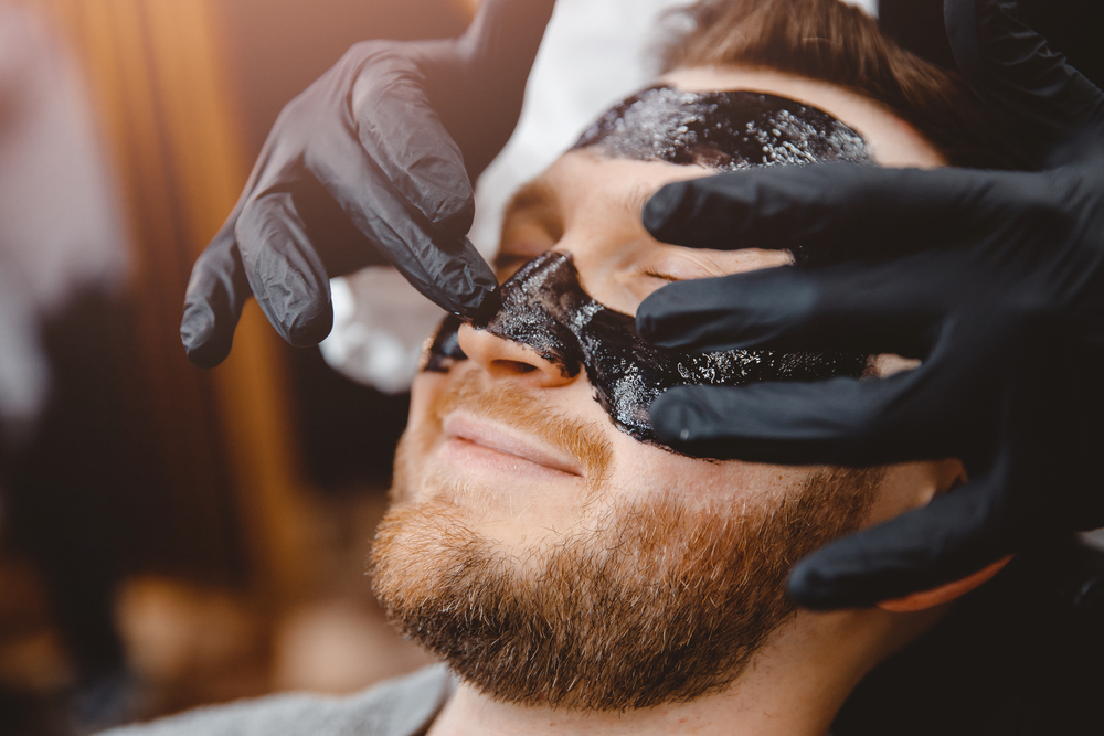 Barber,Applies,Black,Charcoal,Mask,To,Man,Face,To,Clean